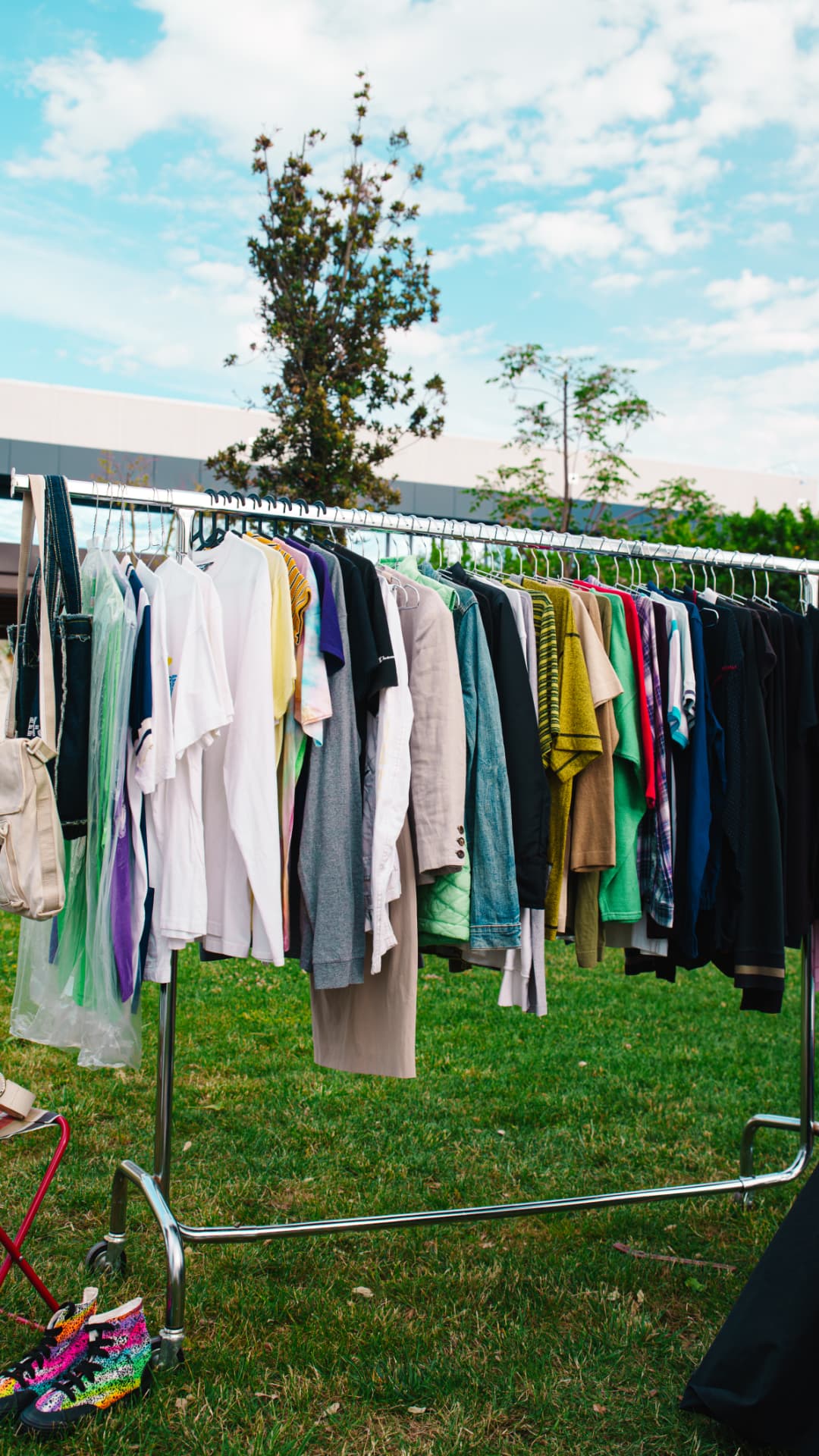 Stand con appendiabiti pieno di capi second hand sul prato