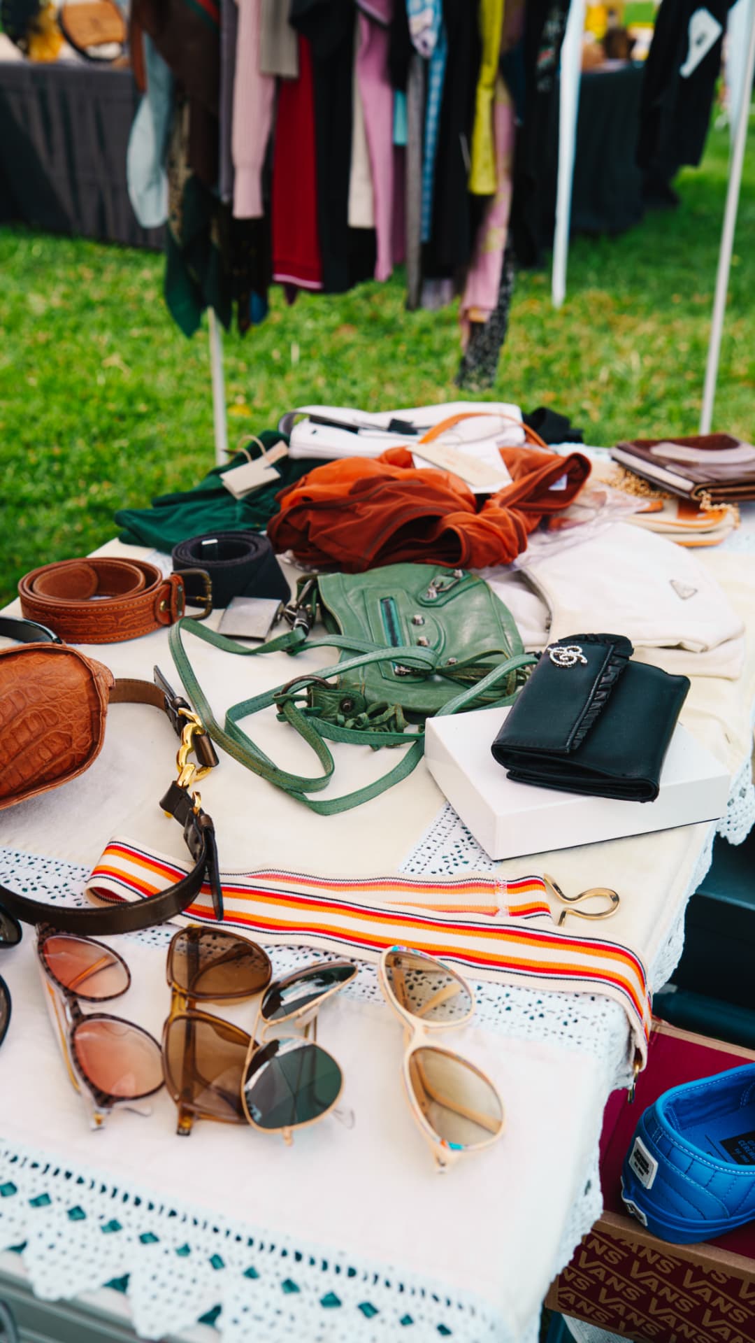 Occhiali da sole, cinture e accessori vintage su un banco